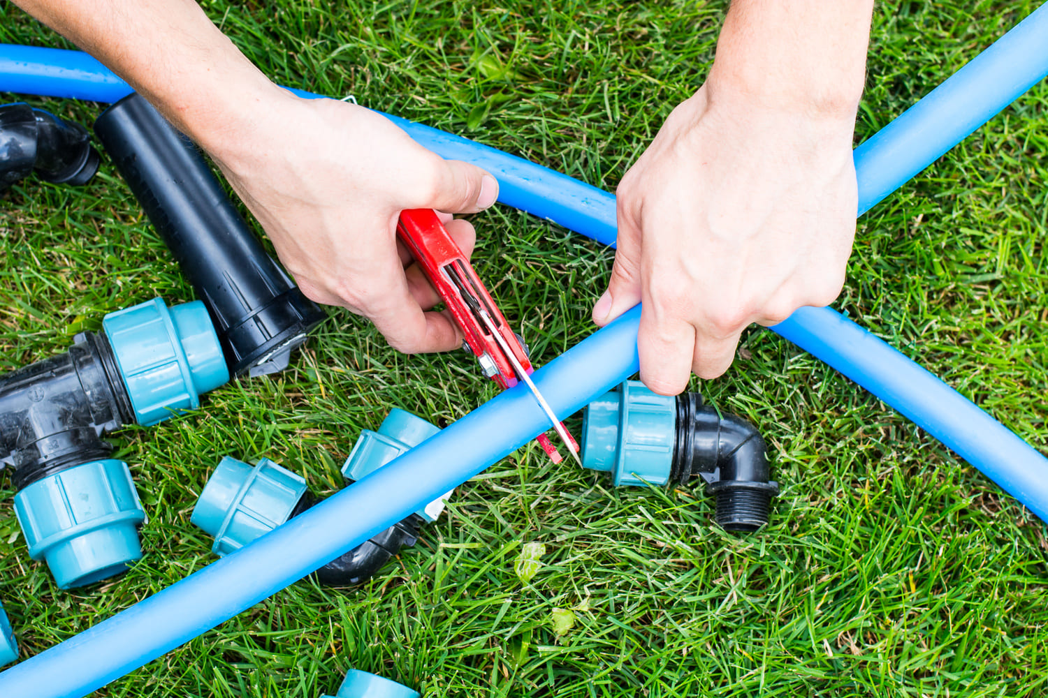 man-cutting a-hose-during-garden-maintenance-London